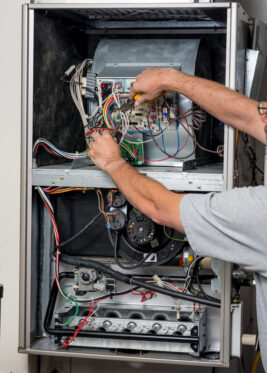 A technician repairing a furnace in Anoka, MN