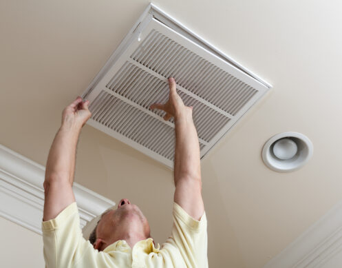 A man changing the air filter of his AC in Anoka, MN